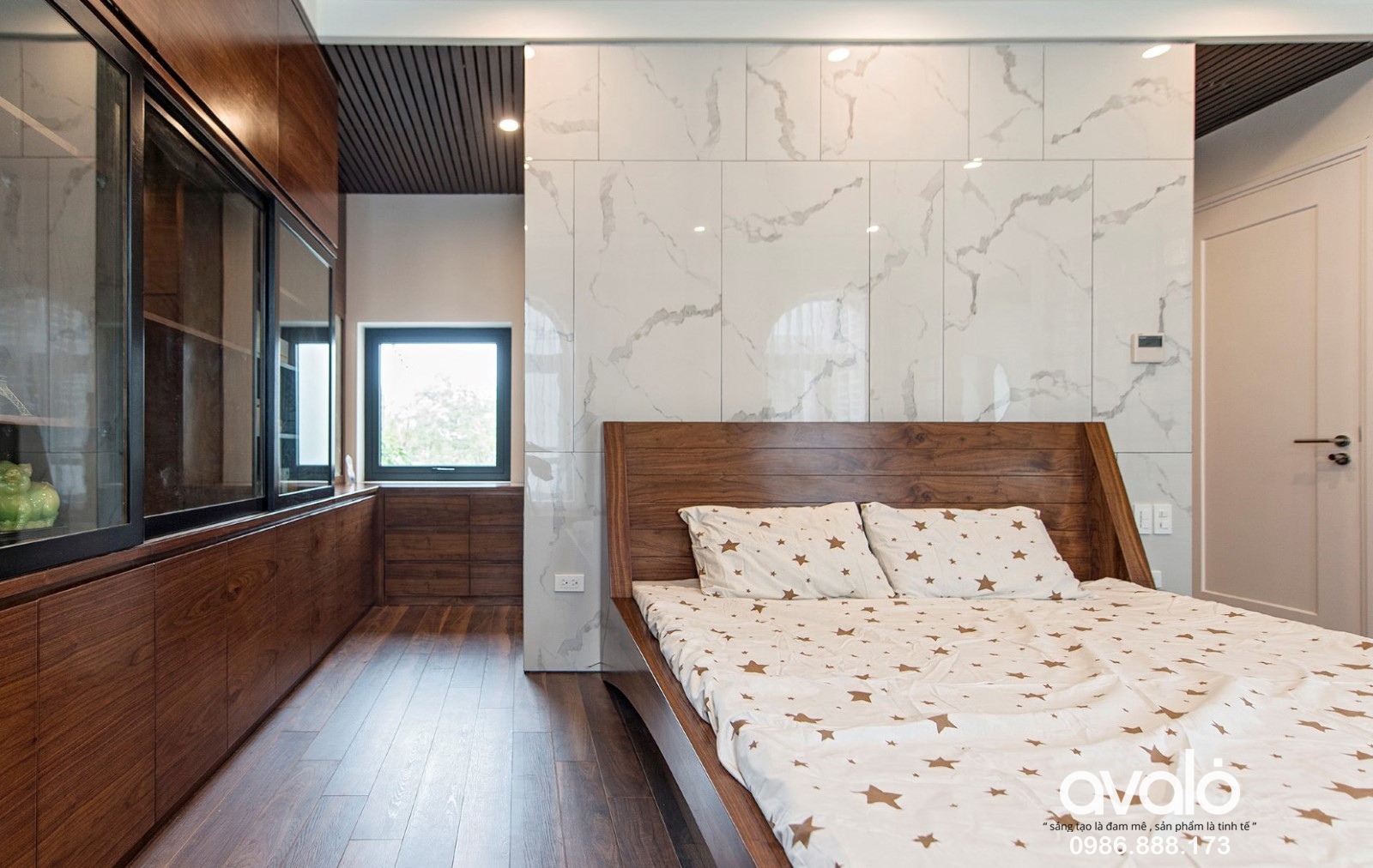 Phòng ngủ lớn trong ngôi nhà 3 tầng có vách đầu giường được ốp đá hoa cương.